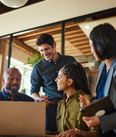 a group of people looking at a laptop