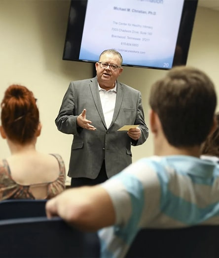 a group of people standing in front of a computer